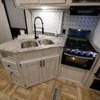 Sink Cover and Glass Cook Top Shown Open to Shown Double Bowl Stainless Steel Sink and Three Burner Cook Top.
