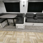U-Shaped Dinette Next to Sofa Shown in Greystone Décor.
