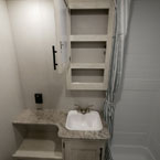 Medicine Cabinet Shown Open to Show Three Shelves. Above Single Bowl Vanity with One Cabinet Door and Two Shelves.
